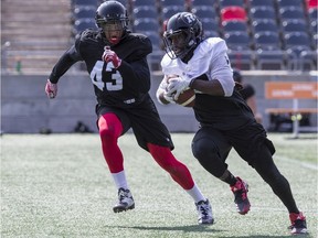 Jonathan Newsome (left) tracks down a ball carrier during a Redblacks practice in late May.