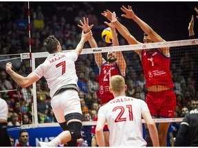 Canada's Stephen Timothy Maar tries to tip the ball through a Serbian block at the net during Sunday's match.