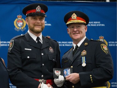 Danijel Avlijas (left) is presented his badge by Interim Police Chief Steven Bell (right) at a graduating ceremony held at the EY Centre.