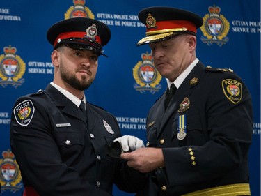 Philippe Berube (left) is presented his badge by Interim Police Chief Steven Bell (right) at a graduating ceremony held at the EY Centre.