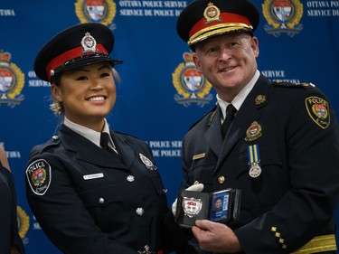 Shelley Dang (left) is presented her badge by Interim Police Chief Steven Bell (right) at a graduating ceremony held at the EY Centre.