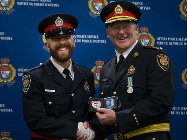 David Martin (left) is presented his badge by Interim Police Chief Steven Bell (right).