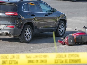Emergency personnel attend to a collision between a scooter type motorcycle and a vehicle along West Hunt Club Rd near Merivale Ave.