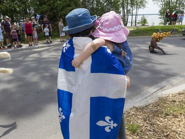A woman and child watch one of the entertainers in the Saint-Jean-Baptiste Day parade in Gatineau on June 24, 2019.