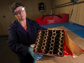 Barb Duff, explosives technologist at the Canadian Explosives Research Laboratory, pulls open a consumer brand of fireworks in order to perform safety tests.