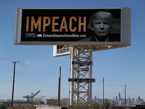 An electronic billboard next to the San Francisco-Oakland Bay Bridge reads "IMPEACH" with an image of U.S. President Donald Trump on September 25, 2017 in Oakland, California.