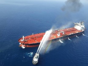 A picture obtained by AFP from Iranian news agency Tasnim on June 13, 2019 reportedly shows an Iranian navy boat trying to control fire from Norwegian owned Front Altair tanker said to have been attacked in the waters of the Gulf of Oman.