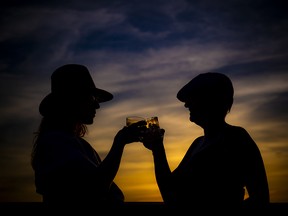 Kelly Dunlap, the Saucy Milliner, and childhood friend Debbie Buttrum cheers as the sun set behind them.