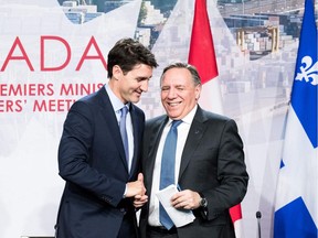 Prime minister of Canada Justin Trudeau (L) with premier of Quebec François Legault (R) shake hands during a meeting with Canadian prime ministers in Montreal, on December 7, 2018 at the Marriott Chateau Champlain.