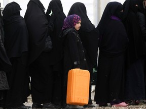 Syrians queue to collect items of delivered aid at the al-Hol refugee camp in northeastern Syria on Jan. 07, 2019.