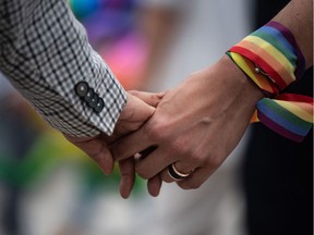 A same-sex couple hold hands during an event to raise awareness of gay rights in Hong Kong on May 25, 2019, one day after Taiwan made history with Asia's first legal gay weddings. - The weddings, which came a week after lawmakers took the unprecedented decision to legalise gay marriage despite staunch conservative opposition, places Taiwan at the vanguard of the burgeoning gay rights movement in Asia.