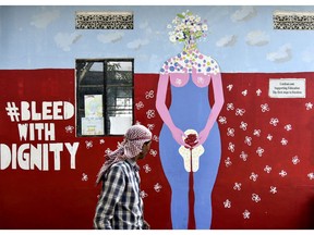A man walks by a wall painting about female menstruation on the Menstrual Hygiene Day in Guwahati, India, on May 28, 2019.