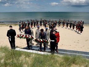 Canadian Prime Minister Justin Trudeau (R) and French Prime Minister Edouard Philippe lays a wreath of flowers during the international ceremony on Juno Beach in Courseulles-sur-Mer, Normandy, northwestern France, on June 6, 2019, as part of D-Day commemorations marking the 75th anniversary of the World War II Allied landings in Normandy.
