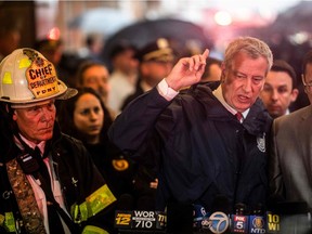 New York City mayor Bill de Blasio, right, addresses the media after a helicopter crash-landed on top of a high-rise in midtown Manhattan on Monday.