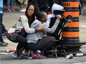 People take cover after reports of shots fired in the area where crowds gathered in Toronto's Nathan Phillips Square to celebrate the Raptors victory parade on Monday.