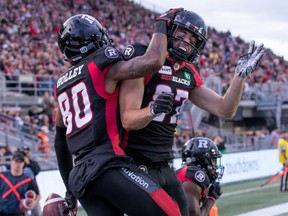 Caleb Holley (L) and Seth Coate celebrate in the end zone after extra points in the first half as the Ottawa Redblacks take on the Saskatchewan Roughriders in CFL action at TD Place in Ottawa.