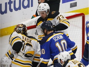 Bruins defenceman Charlie McAvoy (73) watches as netminder Tuukka Rask spins around and reaches back to grab a puck that McAvoy had batted out of harm's way near the goal line during Game 6 in St. Louis on Sunday night.