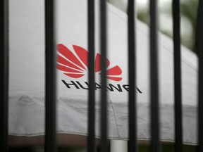 A Huawei logo is seen outside the fence at its headquarters in Shenzhen.
