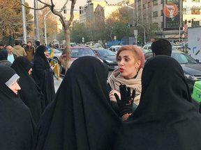 A woman without a hijab is confronted by Iran's "morality police" in a photo posted on social media in February 2018.