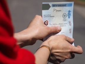 In front of Ottawa City Hall on Monday, May 7, Joshua M. Ferguson shows off their newly acquired birth certificate with a non-binary sex identification.