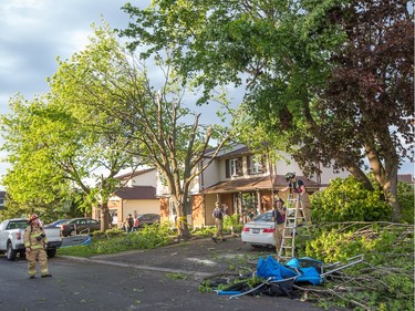 Fire fighters at work clearing damaged branches on Singleton Way as a reported tornado touched down in the Orléans suburb of Ottawa on Sunday evening. Wayne Cuddington / Postmedia