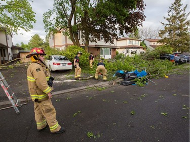 Fire fighters at work clearing damaged branches on Singleton Way as a reported tornado touched down in the Orléans suburb of Ottawa on Sunday evening. Wayne Cuddington / Postmedia