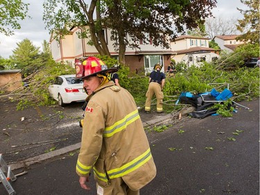 Firefighters at work clearing damaged branches on Singleton Way as a reported tornado touched down in the Orléans suburb of Ottawa on Sunday evening. Wayne Cuddington / Postmedia