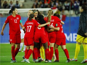 Canadian team members celebrate after completing Saturday's 2-0 victory against New Zealand in Grenobles.