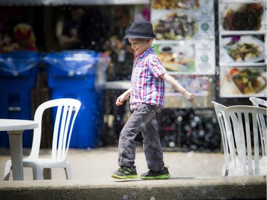 Five-year-old Desmond Hersak walks around the fountain in Confederation Park, in the food area of Ottawa Jazz Festival Saturday June 22, 2019.   Ashley Fraser/Postmedia