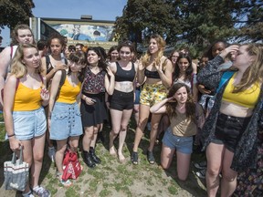 Alexi Halket (centre, yellow shorts, black top) organizes her classmates for a group shot in front of of Etobicoke School of the Arts in Toronto, Ont.  Tuesday May 26, 2015. Halket's  wearing a crop top ran afoul of the schools dress code.