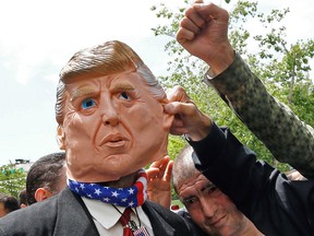 Iranian demonstrators gesture around a mask depicting US.. President Donald Trump during a rally on May 10, 2019 in Tehran.