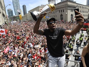 Toronto Raptors forward Kawhi Leonard takes a selfie holding his playoffs MVP trophy as he celebrates during the 2019 Toronto Raptors Championship parade in Toronto on Monday, June 17, 2019.