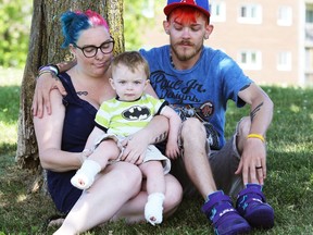 Amanda Insley and Brandon Donnelly hold their one-year-old son Thomas, who received second- and third-degree burns on his feet after he ran across a metal access door located in the ground steps from a Kingston splash pad Sunday.