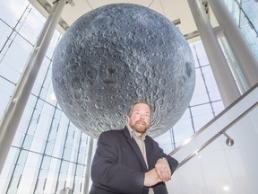 Astronomer Gary Boyle stands under the seven-metre wide moon model at the Canadian Museum of Nature.