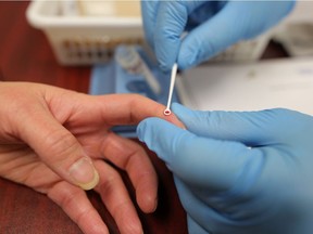 A Calgary pharmacy manager gives an employee a hepatitis C screening test.