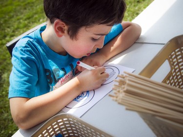 Six-year-old Toomy Moussa focuses on his colouring art Saturday afternoon.   Ashley Fraser/Postmedia