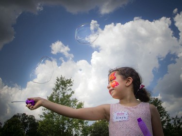 Six-year-old Aleya Aly plays with bubbles in the beautiful weather Saturday afternoon.   Ashley Fraser/Postmedia