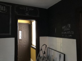 The black “chalkboard paint” on the kitchen walls in of this century home made a small room feel smaller.