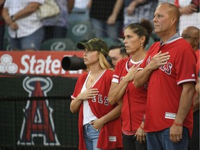 Tyler Skaggs' wife, Carli Skaggs, his mother Debbie Hetman and his stepfather Danny Hetman stand together during the national anthem before Friday's game in Anaheim.