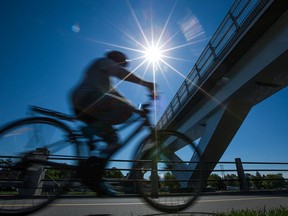 A cyclist rides past the Flora Footbridge.