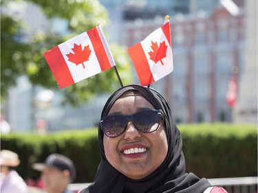 Ikram Abdulkadir sports a pair of Canadian flags as Canada Day activities are in full swing through out the downtown core.
