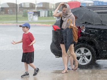 Jacqueline Bell and her son, Frank, 8, run for cover after arriving at the Canadian War Museum during the severe weather as the second day of RBC Bluesfest gets going on Friday evening.