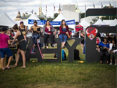 People use the 25 years sign to sit and enjoy Bluesfest Sunday, July 14, 2019, closing night of the festival.