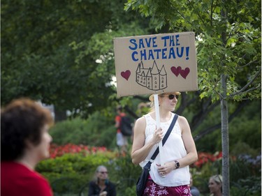 Sheri Frantz holds a sign showing her opinion of the Château Laurier Hotel addition during the Tom Green event at Major's Hill Park on Saturday evening.