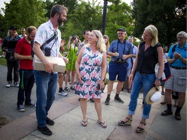 Tom Green speaks with MP Mona Fortier, middle, and Environment Minister Catherine McKenna during Saturday's event at Major's Hill Park.