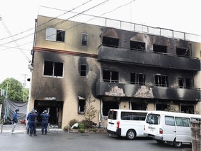 Japanese police officers inspect the scene where over 30 people died in a fire at the Kyoto Animation studio building in Kyoto on July 19, 2019. - Japanese police are investigating a suspected arson that killed 33 people in one of the country's deadliest apparent crimes in decades, with the motive for the blaze still unclear.