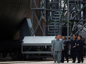 This undated picture released from North Korea's official Korean Central News Agency (KCNA) on July 23, 2019 shows North Korean leader Kim Jong Un (L) inspecting a newly built submarine at an undisclosed location.