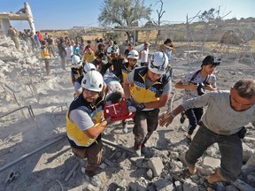 Members of the Syrian civil defence, known as the White Helmets, carry away on a stretcher a victim who was pulled out of the rubble of a collapsed building following reported air strikes by pro-regime forces on Maaret al-Numan in Syria's northwestern Idlib province on July 23.
