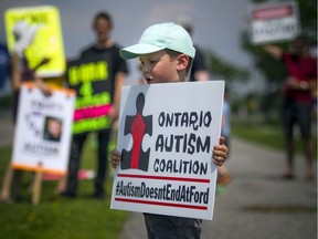 Four-year-old Owen Gibbs holds a sign during the autism rally Saturday, July 6, 2019, outside Lisa MacLeod's office on Fallowfield.