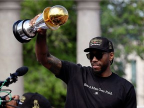 Kawhi Leonard holds his MVP trophy during the Raptors victory parade after defeating the Golden State Warriors in the 2019 NBA Finals, in Toronto on June 17, 2019.